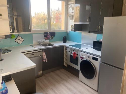 a small kitchen with a washer and dryer in it at Chambre (Pluton) - Proche gare TGV et PARIS in Massy