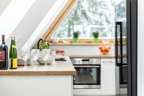 a kitchen with wine glasses on a counter at TatryTop Apartamenty Alpejski SPA in Kościelisko