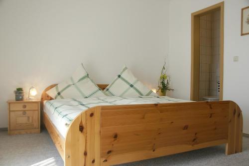 ein Bett mit einem Holzrahmen in einem Zimmer in der Unterkunft Landgasthof Zur Linde in Riedenburg