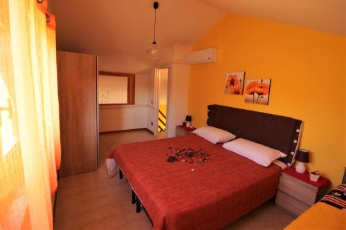 a bedroom with a red bed with a red blanket at I Ginepri in Sorso