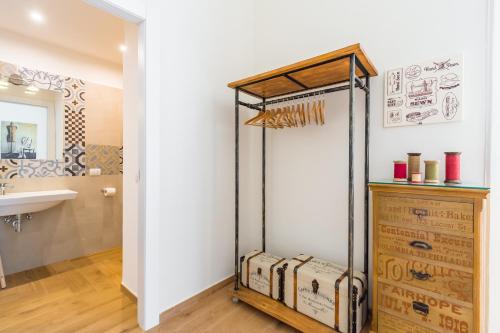 a bathroom with a towel rack and a sink at La Gatta Cenerentola Rooms in Naples