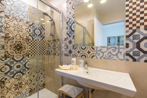 a bathroom with a sink and a shower at La Gatta Cenerentola Rooms in Naples
