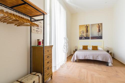 a bedroom with a bed and a dresser in a room at La Gatta Cenerentola Rooms in Naples