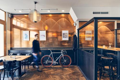 a man walking past a bike in a restaurant at art Hotel Tucholsky in Bochum