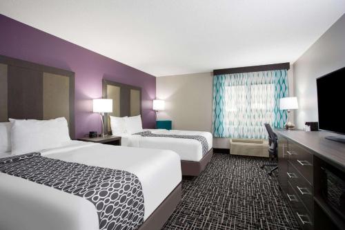 a hotel room with two beds and a flat screen tv at La Quinta Inn by Wyndham Roanoke Salem in Salem