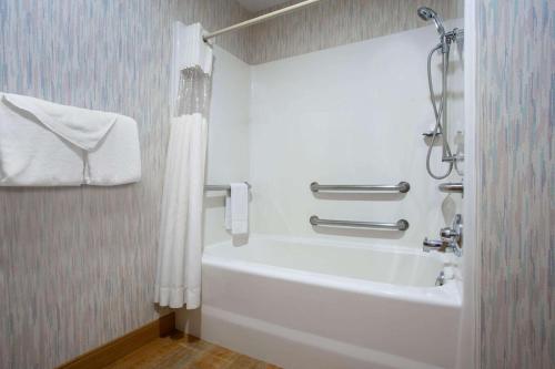 a bathroom with a white tub and a shower at La Quinta Inn by Wyndham Roanoke Salem in Salem