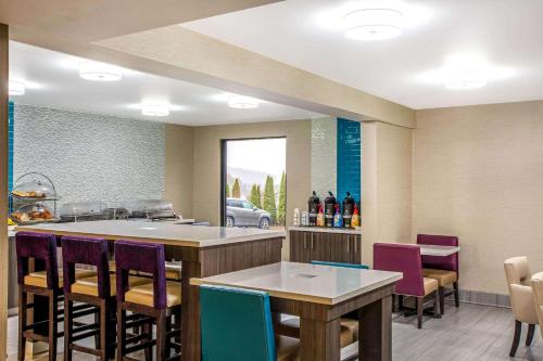 a restaurant with a bar with purple chairs at La Quinta Inn by Wyndham Radford in Radford