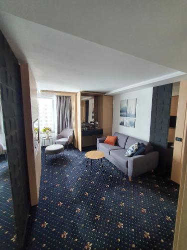 a living room with a couch and a table at Aqvatonic Hotel - Steaua de Mare in Eforie Nord