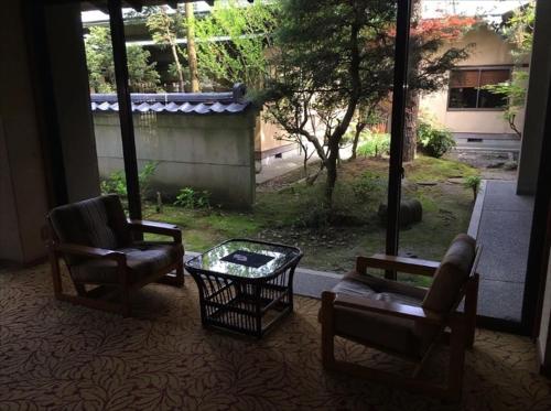 a living room with two chairs and a coffee table at Ryokan Karasawa in Kanazawa