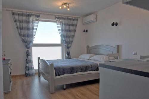 1 dormitorio con cama y ventana grande en Studio D, en Poreč