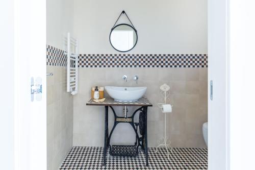 a bathroom with a sink and a mirror at La Gatta Cenerentola Rooms in Naples