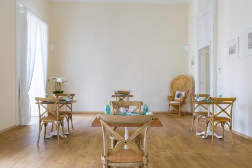 a dining room with tables and chairs in a room at La Gatta Cenerentola Rooms in Naples