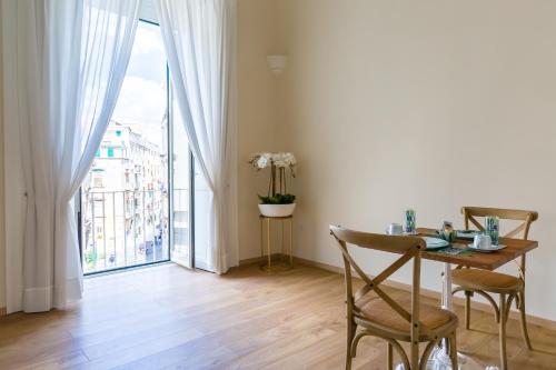 a dining room with a table and a large window at La Gatta Cenerentola Rooms in Naples