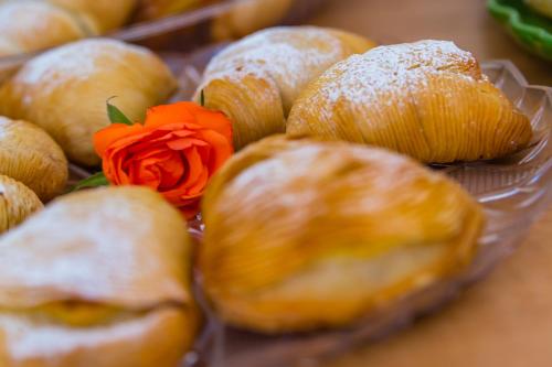 a bunch of pastries with a red rose on top at La Gatta Cenerentola Rooms in Naples