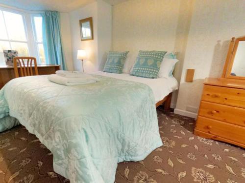 a bedroom with a large bed and a dresser at Strands Hotel/Screes Inn & Micro Brewery in Nether Wasdale
