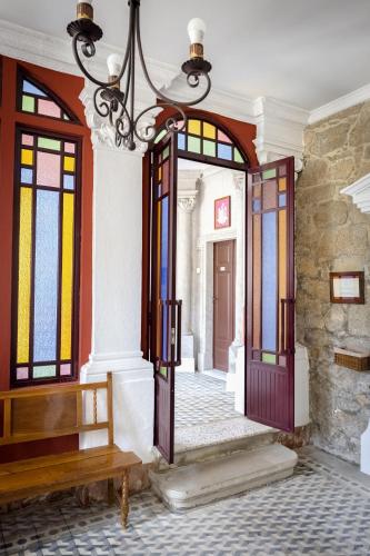 a hallway with stained glass doors and a bench at Balneario Hotel Dávila in Caldas de Reis