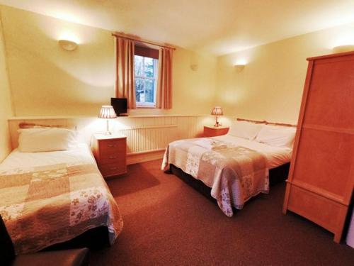 a hotel room with two beds and a window at Strands Hotel/Screes Inn & Micro Brewery in Nether Wasdale