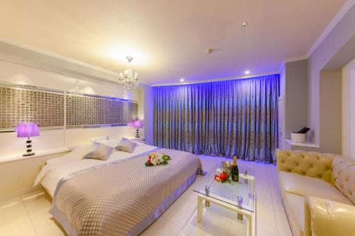 ein Schlafzimmer mit einem großen Bett und einer Couch in der Unterkunft HOTEL MYTH-W -ホテル マイス ダブリュー- adult only in Sakaide
