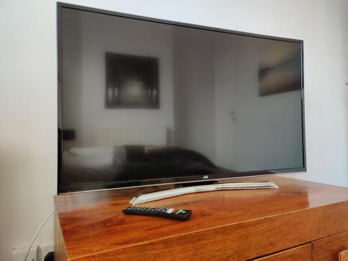 TV con mando a distancia sobre una mesa de madera en Freemantle Solent Lodge SGH, en Southampton