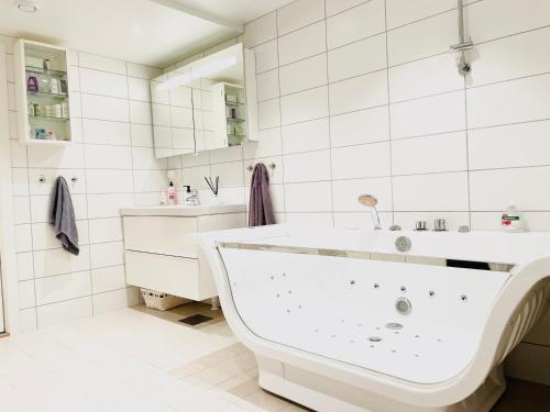 a white bathroom with a tub and a sink at ***UPSCALE***CITY CENTER* in Oslo