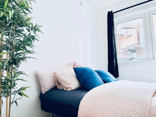 Zimmer mit einem Bett mit Kissen und einem Fenster in der Unterkunft ***UPSCALE***CITY CENTER* in Oslo