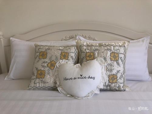 a group of pillows on a bed with a pillow that says have a music at 後山，我的家 in Fenglin