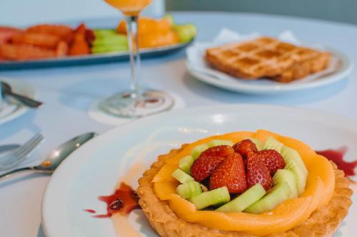 a plate with a waffle with fruit on it at Hotel Spa Republica in Mar del Plata