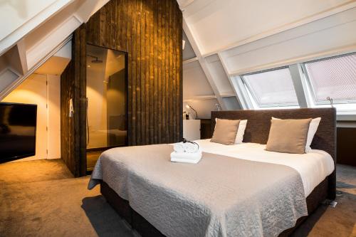 a bedroom with a large bed in a room with windows at Landgoed Kasteel de Hoogenweerth in Maastricht