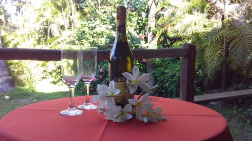 a bottle of wine and two glasses on a table at Okakoaras Hotel in Maria Farinha