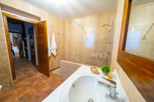 a bathroom with a tub and a shower and a sink at Casa Rural Casa Las Flores in Tíjola