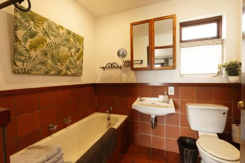 a bathroom with a tub and a toilet and a sink at River View Cottage - at the Breede in Witsand