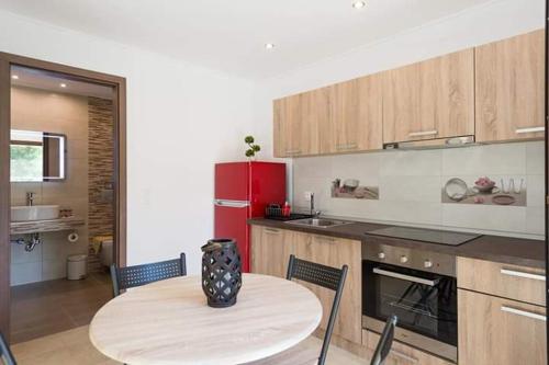 a kitchen with a table and a red refrigerator at Elisabeth Luxury Villas in Vourvourou
