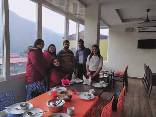 a group of people posing for a picture at a table at Hotel The Shivaay - Delight Inn Rishikesh in Rishīkesh