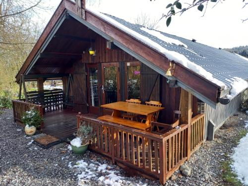 een blokhut met een tafel op het dek bij fraai chalet Barvaux in Durbuy