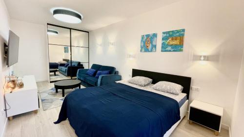 sypialnia z niebieskim łóżkiem i salon w obiekcie SunSea Nadmorskie Tarasy w Kołobrzegu