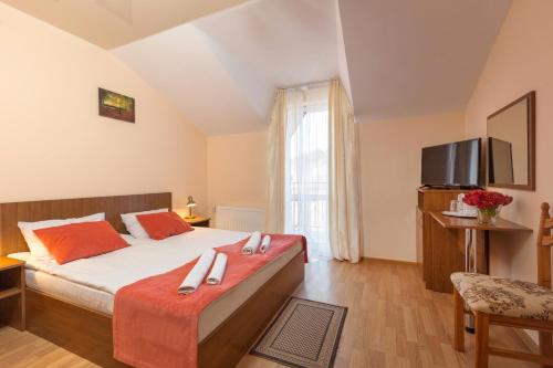 - une chambre avec un grand lit et une télévision dans l'établissement Hotel Citadel, à Skhidnitsa