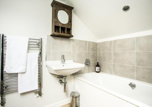 a bathroom with a sink and a bath tub at Hideaway in North Berwick