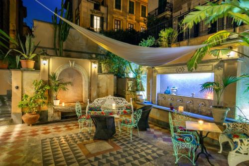 a patio with a table and chairs in a building at Hotel Emona Aquaeductus in Rome