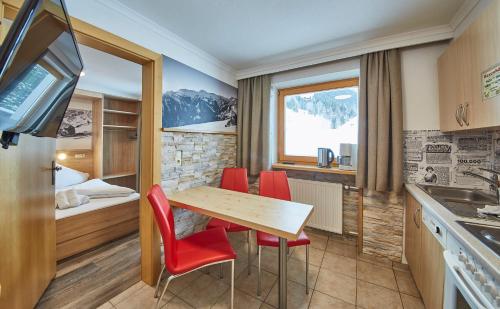a kitchen with a table and chairs in a room at Ski & Bike Appartements Forsthaus in Saalbach Hinterglemm