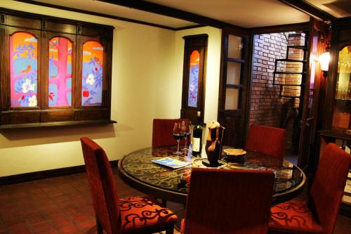 a dining room with a table and chairs and stained glass windows at Casa Glebinias in Chacras de Coria