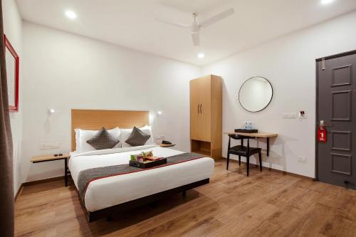 a bedroom with a bed and a table and a mirror at Hotel The Onyx in Nagpur