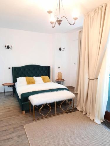 a bedroom with a bed with a green headboard at Apartment A36 Silver Mountain in Poiana Brasov
