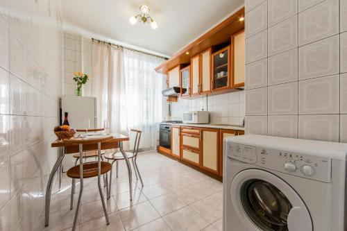eine Küche mit einer Waschmaschine und einem Tisch in der Unterkunft Комфорт-апартаменти біля Хрещатика, безконтактне заселення 24х7 in Kiew