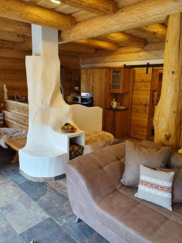 a living room with a couch in a log cabin at Almzauber Chalets Hochrindl in Hochrindl