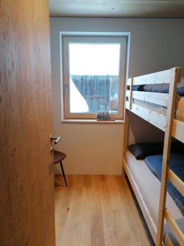 a bedroom with two bunk beds and a window at Kanis 80 in Schnepfau