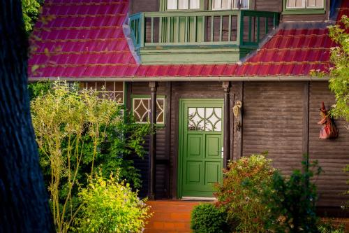 a house with a green door and a red roof at Matys Landhausperle an der Müritz in Röbel