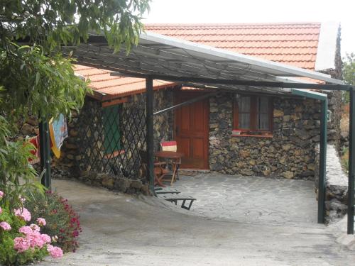 a stone house with a bench in front of it at Casa Rural Abuelo Pancho in Las Casas