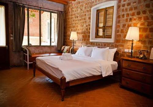a bedroom with a large bed in a brick wall at La Toscana in Suan Phung
