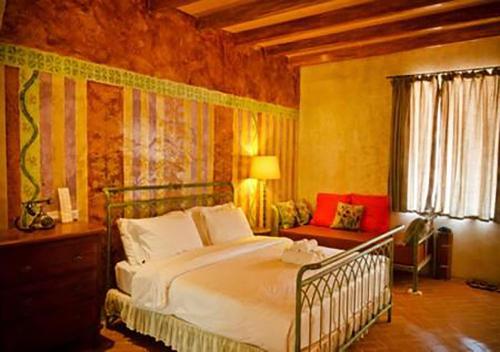 a bedroom with a large bed and a couch at La Toscana in Suan Phung