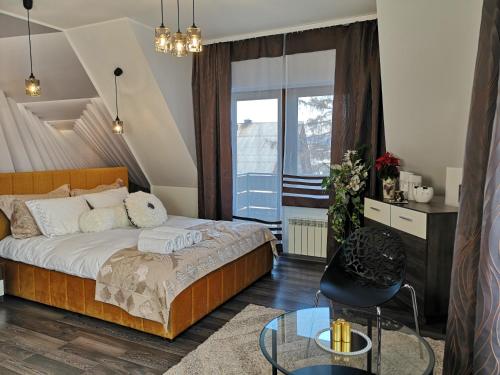 Apartament Podhale في Raba Wyżna: غرفة نوم بسرير وطاولة زجاجية